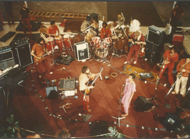 Darshan-Satsang band, Rajneeshpuram, 1984 : clockwise from left: Sw Prem Geet (bass), Sw Shiven (congas), Nivedano (drums), Sw Govinddas (guitar), Sw Devakant (flutes), Sw Santosh Toby (saxophone), Ma Anand Suresha (vocals) & Sw Prem Anubhava (vocals & guitar)