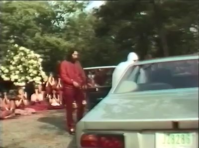 File:Osho at Chidvilas (1981) ; still 01min 39sec Swami Prem Vadan opening door.jpg